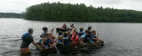 young children paddling boat in a pond