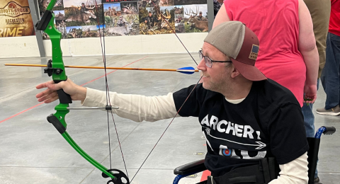 man shooting a bow using one arm