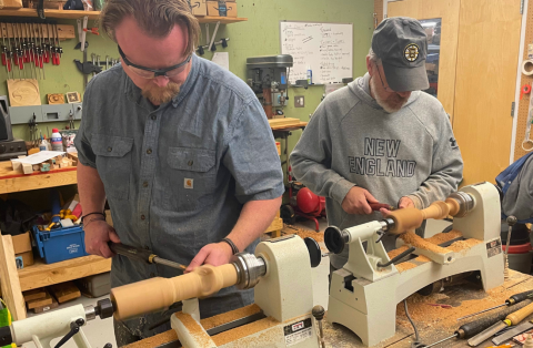 two men turning wood on lathes